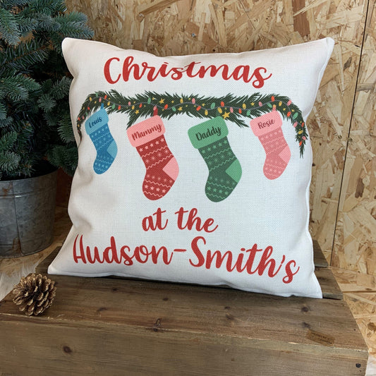 Christmas cushion with family names and row of stickings over fireplace